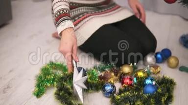 年轻快乐的女人装饰圣诞<strong>树</strong>，拿着<strong>一颗</strong>银星，挂在<strong>树</strong>顶上。 慢动作
